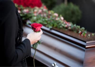 Donna che porta un fiore in omaggio a un funerale